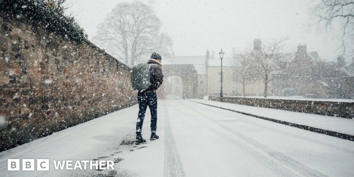 Man walks along a snow covered street with a rucksack on his back