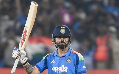 India batter Virat Kohli raises his bat to celebrate a century for his team.