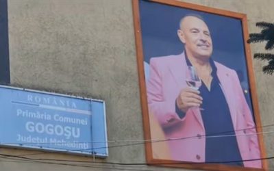Tablouri cu primarul decedat din Mehedinți, ținând paharul de vin la primărie