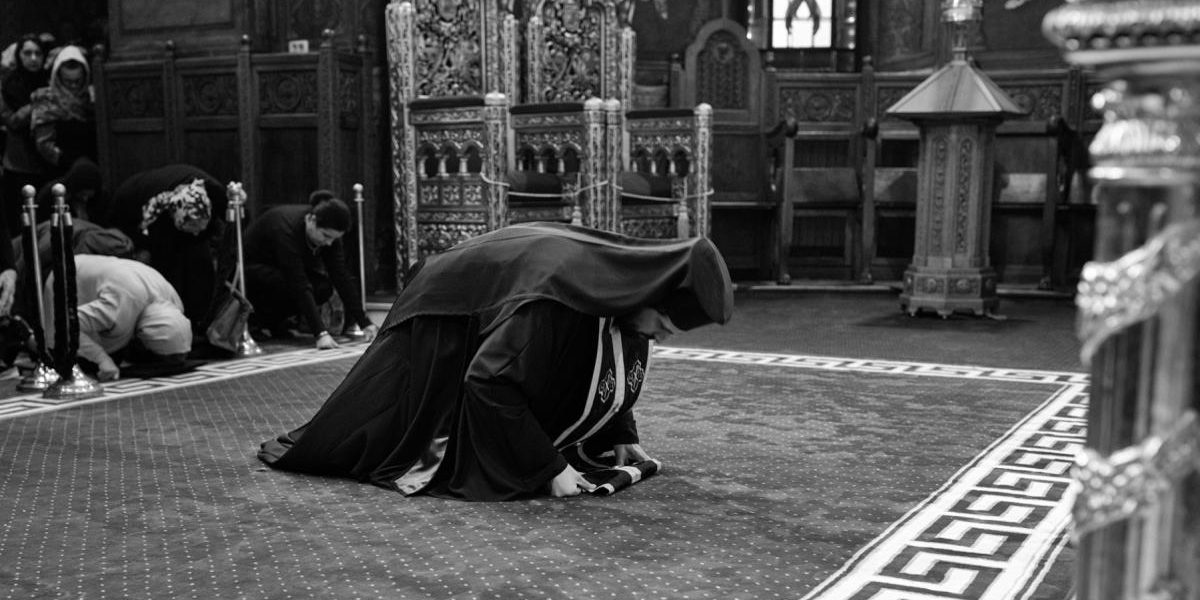 preot ortodox in genunchi biserica romania saptamana mare