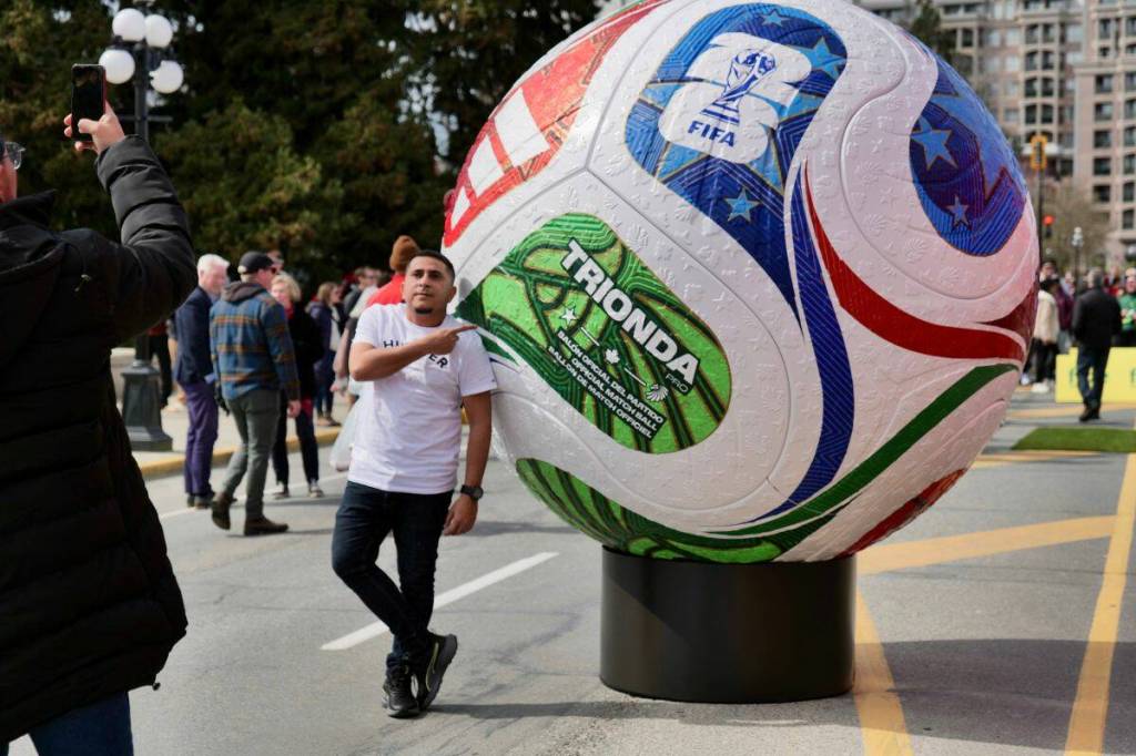 A fan snaps a photo alongside a giant soccer ball display outside the B.C. legislature in March. Nelson will host a FIFA event on June 24 at Lakeside Park. (Tony Trozzo/Victoria News)