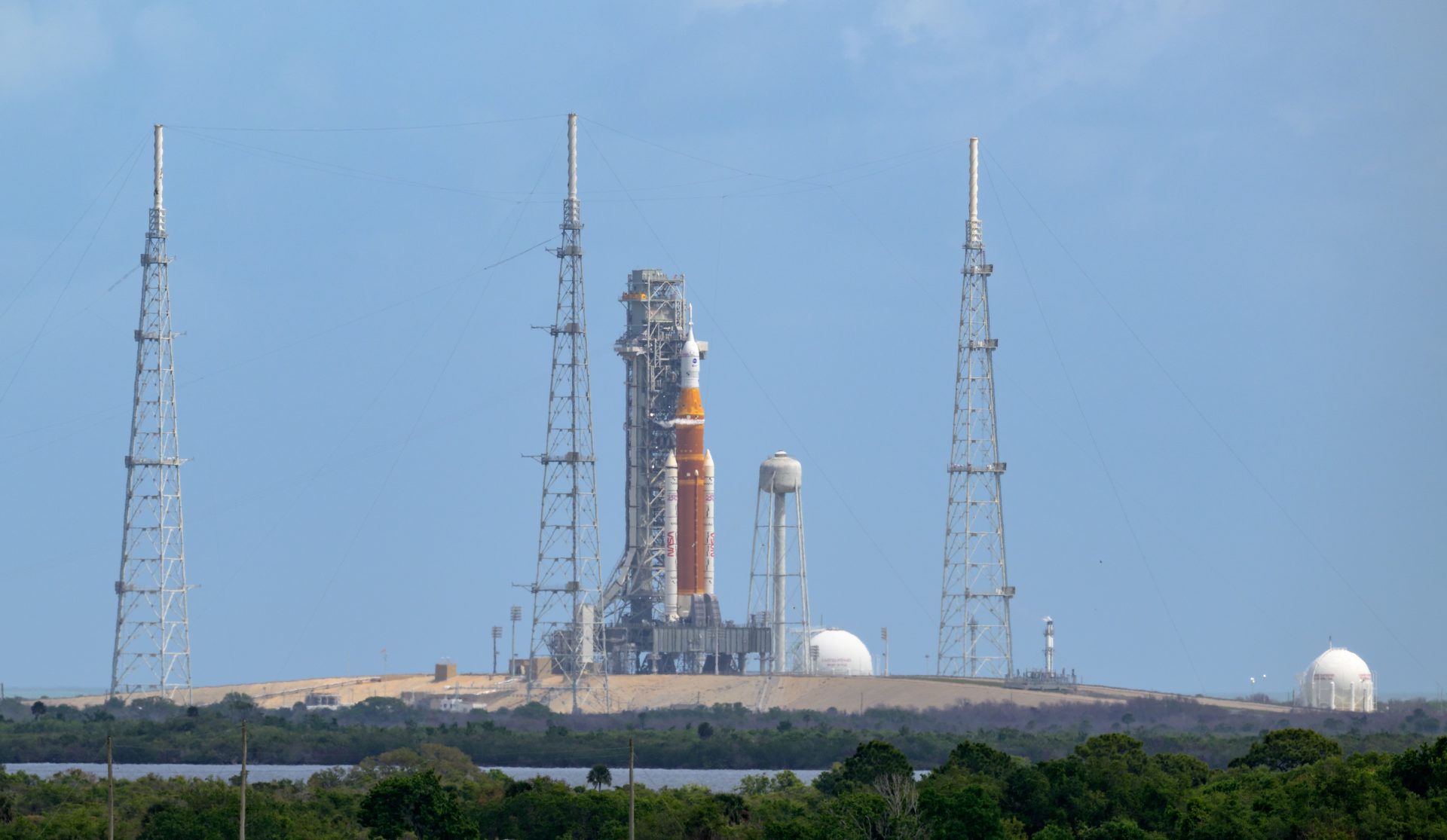 Image shows the orange core stage of the NASA’s Space Launch System (SLS) rocket with the white spacecraft on top making up of the Orion spacecraft at NASA's Kennedy Space Center in Florida.